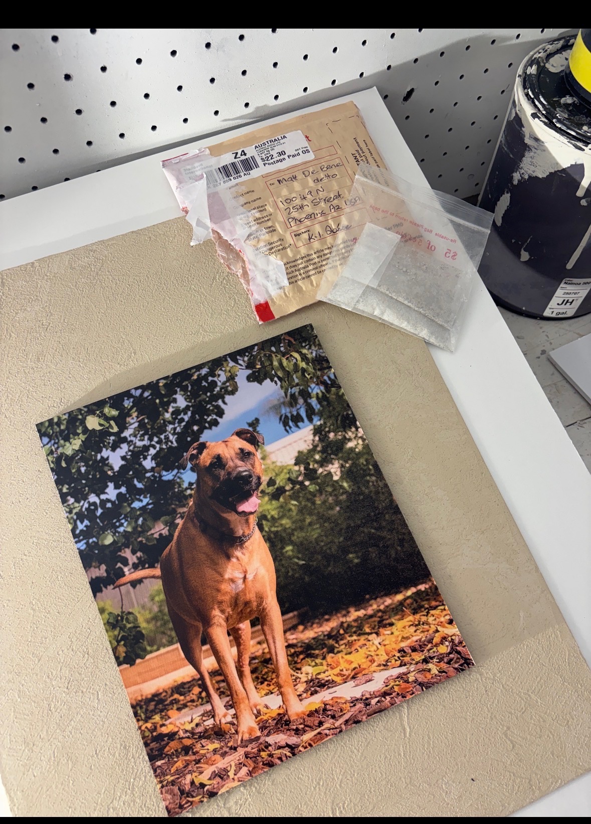Ash & Earth studio — the raw materials: a panel board, a photo print, and a small package of ashes